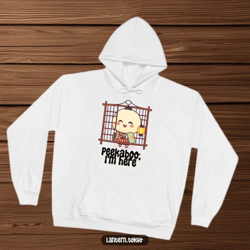 Funny hoodie showing a smiling rice ball lantern in a kimono playfully peeking from behind a screen, embodying cute mischief.